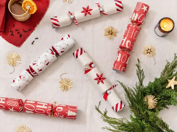 Christmas crackers fai da te con Babbo Natale, fiocchi di neve e scritte "Ho Ho Ho". Decorazioni natalizie fatte a mano.