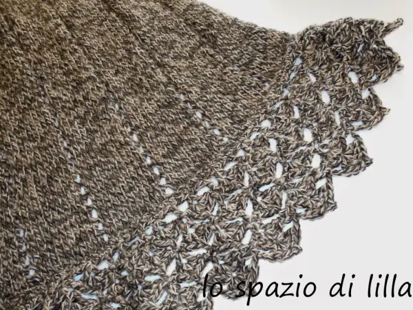 Mantella ai ferri con bordo all'uncinetto, filato screziato marrone e beige, un capo caldo e raffinato.