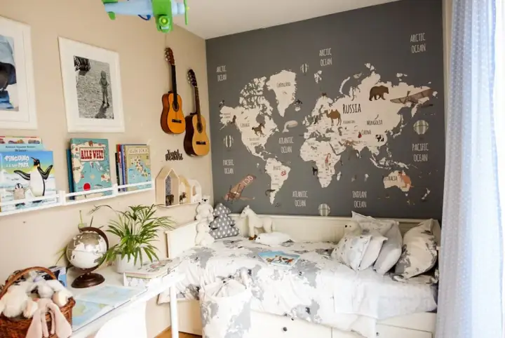 Camera da letto con mappa del mondo e decorazioni tema viaggio: aerei, mongolfiere, animali e chitarre.